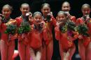 Second placed team China pose with the silver medals on the podium after the women's team final competition at the World Artistic Gymnastics championships at the SSE Hydro Arena in Glasgow, Scotland, Tuesday, Oct. 27, 2015. (AP Photo/Matthias Schrader)