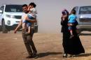 An Iraqi family fleeing violence in the northern Nineveh province arrives at a Kurdish checkpoint in Aski kalak on June 11, 2014
