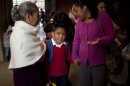 Diego Angel is consoled by his mother Dulce Castro, right, and grandmother Margarita as he is escorted to the first day of classes in Mexico City, Monday, Aug. 19, 2013. Mexican children returned to classrooms Monday, and they were getting a quick lesson: Not just school kids make mistakes. Their brand new textbooks have the kinds of errors that they are supposed to be learning not to make: words written with a "c'' instead of an "s," too many commas, not enough accents and at least one city located in the wrong state. (AP Photo/Ivan Pierre Aguirre)