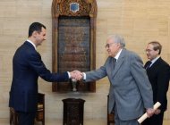 Syrian President Bashar al-Assad (left) shakes hands with peace envoy Lakhdar Brahimi during their meeting in Damascus. Brahimi has urged the two sides in Syria's conflict to declare a unilateral truce for this week's Muslim holidays after meeting Assad, even as a deadly bomb rocked Damascus