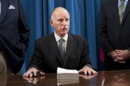 Gov. Jerry Brown signs the state budget surrounded by Assembly Speaker John A. Perez, D-Los Angeles, left, and Senate President Pro Tem Darrell Steinberg, D-Sacramento, right, on Thursday, June 30, 2011 at the state Capitol in Sacramento, Calif.. (AP Photo/Hector Amezcua, pool)