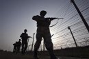 Indian BSF soldiers patrol the fenced border with Pakistan in Suchetgarh
