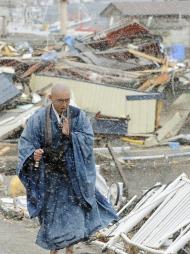 Un monje budista ofrece oraciones mientras camina atravé de una zona destruida por el tsunami en la localidad de Yamada, en la provincia de Iwate, al norte de Japón el lunes 4 de abril del 2011. (Foto AP/Kyodo News)