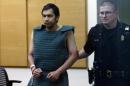 Shooting suspect Aaron Ybarra, left, is led in chains to a court hearing at a King County Jail courtroom Friday, June 6, 2014, in Seattle. Ybarra was arrested in the killing of a 19-year-old student and wounding of two other young people Thursday at Seattle Pacific University. Police say another student pepper-sprayed and tackled him. (AP Photo/Elaine Thompson)