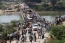 People cross a bridge after a stampede near Ratangarh temple in Datia