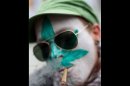FILE - In this Friday April 20, 2012 file photo a protestor from Belgium with a marijuana leaf painted on his face smokes a marijuana joint in Amsterdam during a protest against a government plan to stop foreigners from buying marijuana in the Netherlands. A Dutch judge has upheld the government's plan to introduce a 