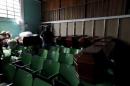 A volunteer rests in a church auditorium as they collect aid for mudslide victims in Santa Catarina Pinula