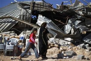 Palestinians walk past a structure after it was demolished …
