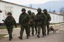 Armed men, believed to be Russian servicemen, march outside Ukrainian military base in Perevalnoye