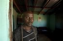File photo of former gold miner Bitsha standing in the doorway to his home near Bizana in South Africa's impoverished Eastern Cape province