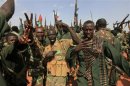 Sudanese military soldiers flash victory signs and hold up their weapons during the visit of Sudanese President Omar al-Bashir in Heglig
