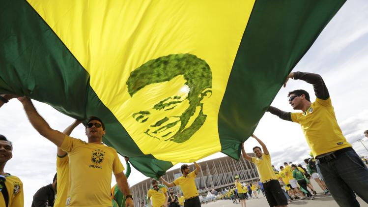 Brazil fans carry a picture of soccer legend Pele before the 2014 World Cup Group A soccer match between Cameroon and Brazil at the Brasilia national stadium