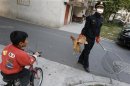 A city management officer holds a chicken as a boy rides past in a residential neighbourhood of Jiaxing