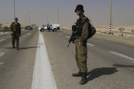 Israeli security forces secure the area after an attack, near the southern Israeli city of Beersheva, Monday, June 18, 2012. Unidentified militants crossed from Egypt's turbulent Sinai Peninsula into southern Israel on Monday, opening light arms and anti-tank fire on civilians building a security fence meant to fortify the porous border, defense officials said. One of the Israeli workers was killed, and two militants were gunned down by troops responding to the attack, the officials said. (AP Photo/Tsafrir Abayov)