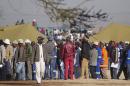 Mineworkers queue near Lonmin's Marikana platinum mine before returning to work