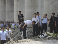 Chinese Premier Wen Jiabao, center, bows after he laid flowers at the site of the Saturday July 23, 2011 train crash, in Wenzhou, east China's Zhejiang province, Thursday, July 28, 2011. Wen vowed Thursday to punish anyone involved if there was corruption that caused the high-speed train crash that killed more than 35 people, amid growing public resentment of the handling of the accident. (AP Photo) CHINA OUT