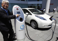 Nissan Motor Co. chief vehicle engineer Hidetoshi Kadota demonstrates a quick charge of a Nissan Leaf by a solar-assisted EV charging system at Nissan's global headquarters in Yokohama, Monday, July 11, 2011. Nissan is testing a super-green way to recharge its Leaf electric vehicle using solar power, part of a broader drive to improve electricity storage systems. In the new charging system, electricity is generated through 488 solar cells installed on the roof of the Nissan headquarters building. Four batteries from the Leaf had been placed in a box in a cellar-like part of the building, and store the electricity generated from the solar cells, which is enough to fully charge 1,800 Leaf vehicles a year, according to Nissan. (AP Photo/Koji Sasahara)