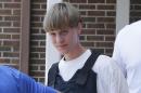 FILE - In this June18, 2016 file photo, Dylann Storm Roof is escorted from the Sheby Police Department in Shelby, N.C. The trial for Roof, a white man accused of killing nine black people at the church, started Wednesday, Dec. 7, 2016, at the federal courthouse in Charleston, S.C. (AP Photo/Chuck Burton, File)
