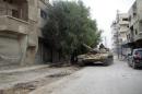 A pro-regime tank drives through the streets of Sbeineh south of Syrian capital Damascus on November 7, 2013