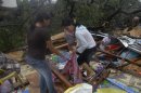 Residents retrieve their belongings after their house was destroyed by a fallen tree caused by Typhoon Bopha in Cagayan de Oro City