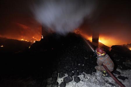 A firefighter tries to control a fire at a garment factory in Savar, outskirts of Dhaka November 24, 2012. REUTERS/Andrew Biraj