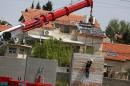 An Israeli crane lifts a section of concrete for a defensive wall around the Israeli settlement of Beit El, in the occupied West Bank north of Ramallah on April 7, 2015