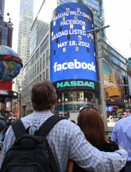 Matts and Maria Nedermam, tourists visiting from Sweden, view Nasdaq's giant monitor as it shows a welcome message for Facebook before the company began trading on the Nasdaq stock market, Friday, May 18, 2012, in New York. (AP Photo/Bebeto Matthews)