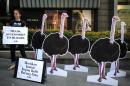 Manager of international operations for PETA, Ashley Fruno, displays a sign next to paper cut-outs of ostriches in front of a Prada store, during a protest in Kuala Lumpur, Malaysia on April 19, 2016