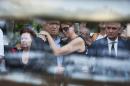 Family members of the victims killed in Malaysia Airlines Flight MH17 plane disaster are seen reacting next to Mayor Pieter Broertjes through the window of a hearse carrying the victims' bodies, in Hilversum