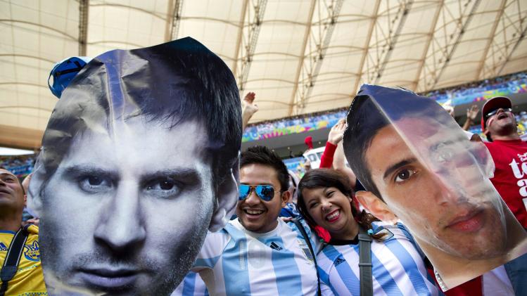 Fans of Argentina&#39;s national soccer team hold face cutouts of Lionel Messi, left, and Angel Di Maria, during the World Cup quarterfinal match between Argentina and Belgium at the Estadio Nacional  in Brasilia, Brazil, Saturday, July 5, 2014