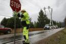 A worker directs traffic as crews work to restore power lines along Issaquah-Hobart Road Southeast in Issaquah, Washington