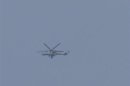 A helicopter belonging to Syrian President Bashar-Al Assad's forces flies over Houla, near Homs