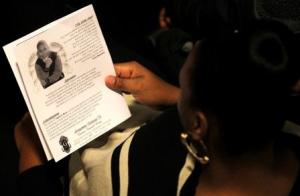 A mourner reads the obituary from the program during&nbsp;&hellip;