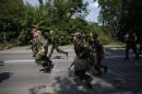 Pro-Russian separatist fighters from the so-called Battalion Vostok (East) run into position at a checkpoint in Donetsk