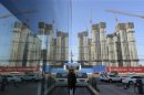 A construction site of a residential compound is reflected on the glass facades of a office building in Taiyuan