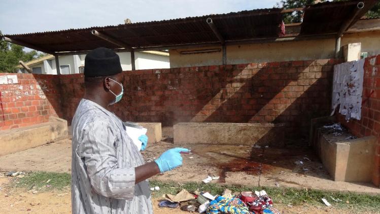 A police detective inspects the site of a suicide blast outside the central administration building of the Kano State Polytechnic institute in the northern Nigerian city of Kano on July 30, 2014