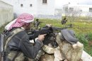 Free Syrian Army fighters hold their weapons and take positions in preparation for what they say is an ambush against forces loyal to Syria's President Bashar al-Assad in Binnish in Idlib Province