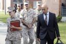 FILE - In this Aug. 21, 2014, file photo, defense attorneys 1st Lt. Brittaney Bennett, left, and Haytham Faraj, right, escort Cpl. Wassef Ali Hassoun, center, to his Article 32 hearing at Camp Lejeune, N.C. Prosecutors could have a difficult time proving the desertion case against Hassounm a U.S. Marine who vanished from his unit in Iraq a decade ago, according to a military report. Hassoun's attorney cites the difficulty in producing witnesses in his request this week for another chance to dissuade the Marines from taking the case to trial. (AP Photo/The Jacksonville Daily News, John Althouse)