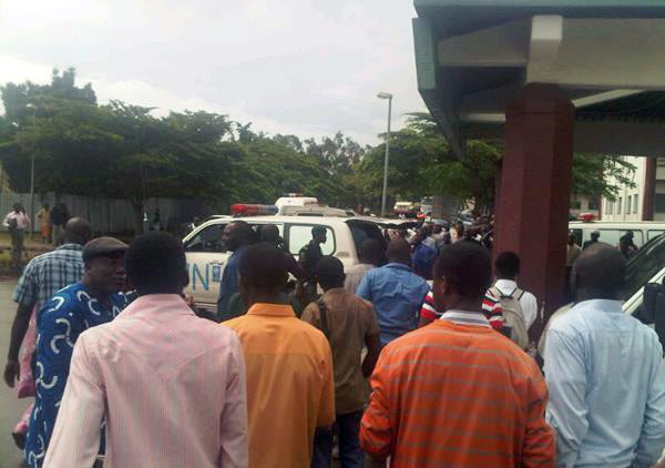 This citizen journalism photo acquired by the AP shows crowds of people outside the the National Hospital in Abuja, Nigeria as an ambulances arrive Friday Aug. 26, 2011 following a large explosion whi