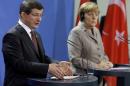 German Chancellor Angela Merkel, right, and the Prime Minister of Turkey Ahmet Davutoglu address the media during a joint press conference after a meeting at the chancellery in Berlin, Germany, Monday, Jan. 12, 2015. (AP Photo/Michael Sohn)