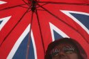 A fan holds an umbrella during a rainy afternoon at the Beach Volleyball venue at the 2012 Summer Olympics, Sunday, July 29, 2012, in London. (AP Photo/Petr David Josek)