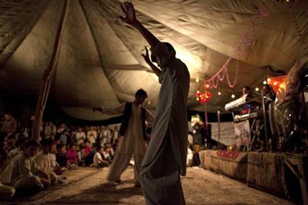 Afghan Hazara men dance during a reception for a groom before a wedding in Bamiyan