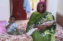 In this file image made from an undated video provided Thursday, June 5, 2014, by Al Fajer, a Sudanese nongovernmental organization, Meriam Ibrahim, sitting next to Martin, her 18-month-old son, holds her newborn baby girl that she gave birth to in jail last week, as the NGO visits her in a room at a prison in Khartoum, Sudan. Sudan's official news agency, SUNA, said the Court of Cassation in Khartoum on Monday, June 23, canceled the death sentence against 27-year-old Meriam Ibrahim after defense lawyers presented their case. The court ordered her release. (AP Photo/Al Fajer, File)