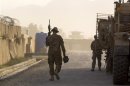 A soldier from the 4th Brigade Combat Team, 4th Infantry Division walks with his weapon to an MRAP while preparing to leave in a convoy inside FOB Joyce in Afghanistan's Kunar Province
