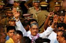 Sri Lanka's former army chief Sarath Fonseka waves to his supporters as he walks out of a jail in Colombo, Sri Lanka, Monday, May 21, 2012. Fonseka's release came after Foreign Minister G.L. Peiris met with U.S. Secretary of State Hillary Rodham Clinton on Friday in Washington, with the protection of human rights highlighted in their meeting. The U.S. has called Fonseka a political prisoner. Fonseka had been credited with leading Sri Lanka's army to victory in the country's long and bloody civil war against ethnic Tamil rebels, but he was jailed after challenging President Mahinda Rajapaksa in 2010 elections. (AP Photo/Gemunu Amarasinghe)
