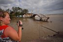 A woman takes video of the flood in the Black Sea resort of Gelendzhik, southern Russia, Saturday, July 7, 2012. Intense flooding in the Black Sea region of southern Russia killed 103 people after torrential rains dropped nearly a foot of water, forcing many to scramble out of their beds for refuge in trees and on roofs, officials said Saturday. (AP Photo/Ignat Kozlov)