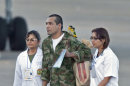 Army sergeant Robinson Salcedo Guarin, center, accompanied by medical personnel, walks with two birds perched on his shoulder upon his arrival at an airport after being released by the Revolutionary Armed Forces of Colombia, or FARC, in Villavicencio Colombia, Monday, April 2, 2012. Colombia's main rebel group on Monday freed what it says were its last 10 soldier and police captives, all of whom had been held in jungle prisons for at least 12 years. (AP Photo/Fernando Vergara)