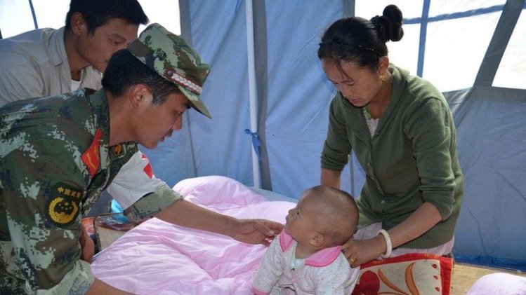 Rescuers take care of a baby following an earthquake in Deqin, southwest China's Yunnan province on August 31, 2013