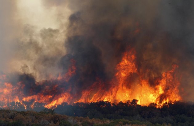 A wildfire roars through dry trees near  Possum Kingdom Lake, Texas, Wednesday, Aug. 31, 2011.   Texas and Oklahoma are in the grips of a record-setting drought, and a summer of soaring temperatures a