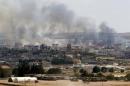 Smoke rises in the Syrian town of Kobani as it is seen from the Turkish border town of Suruc